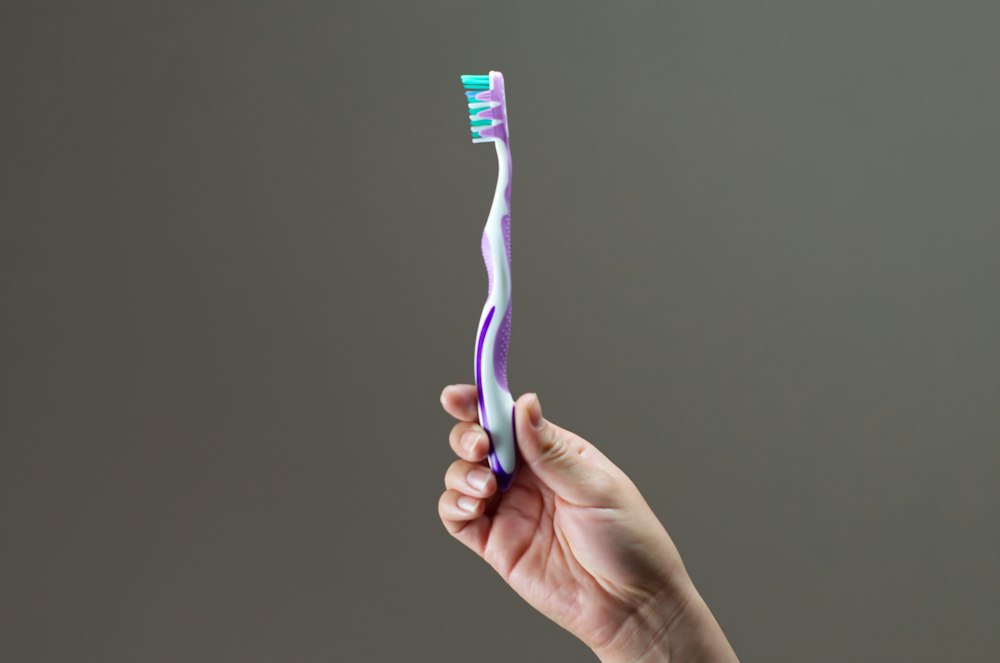 Cepillo de dientes sostenido en una mano